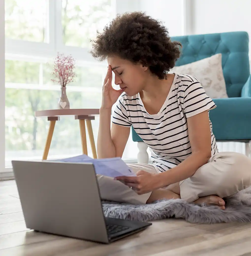Mujer reflexionando frente al ordenador mientras escribe, representando la reprogramación mental a través del lenguaje escrito y la Ley de la Atracción